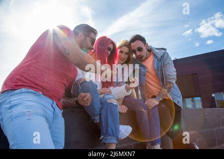 group of four young friends having fun with a phone Stock Photo