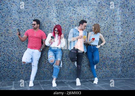 group of four young friends using mobile phone Stock Photo