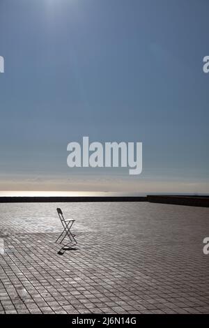 A wooden chair standing in the middle of an empty stage. Loneliness concept with one chair Stock Photo