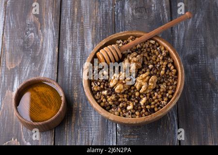 Sochivo, kutya - traditional Slavic holiday ritual dish (Russian, Ukrainian, Belarusian) of whole wheat, poppy, walnuts and honey in wooden bowl on wo Stock Photo