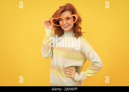happy redhead woman wear funny party glasses on yellow background, celebration Stock Photo