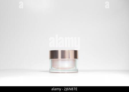 A mock up jar of cream isolated on a white gray background, on a white table with hard shadows. Stylish look of the product, identity. Stock Photo