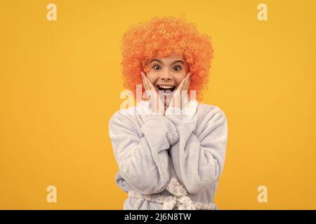 childhood happiness. birthday or pajama party. funny kid in curly clown wig. Stock Photo