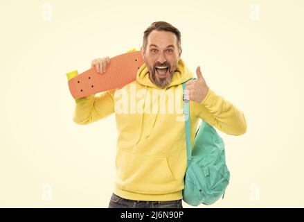 smiling senior guy back to school isolated on white. man in yellow hoody with skateboard. Stock Photo