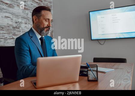 Businessman working with laptop and papers on desk Stock Photo