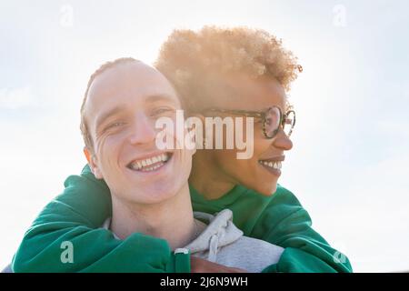 portrait of a young couple of latin woman and caucasian man smiling happy at sunset, concept of friendship and couple relationship Stock Photo