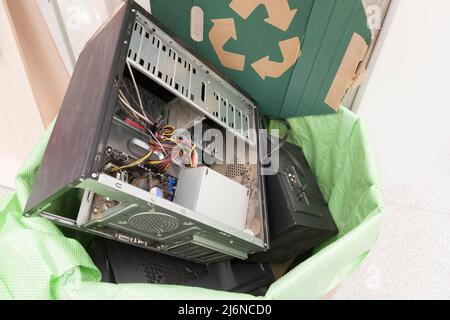 E-waste, electronics waste for reuse and recycle concept. Recycling bin full of old electronic devices in office building. Stock Photo