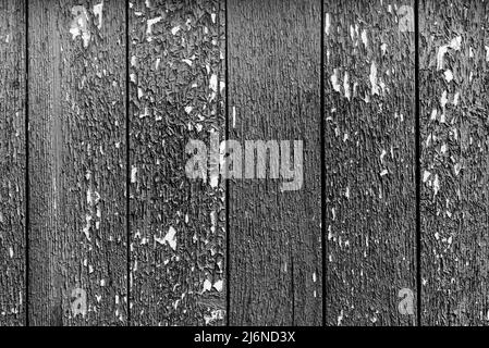 Black and white wooden fence made of planks. Background from boards with cracked paint Stock Photo