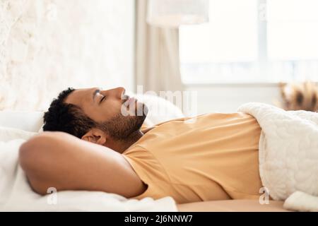Middle Eastern Male Sleeping Lying In Cozy Bed In Bedroom Stock Photo