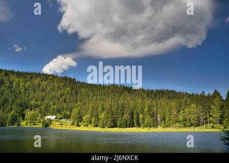 Beautiful lake Kleiner Arbersee with the restaurant and a dramatic cloud over it. Bavarian Forest, Upper Palatinate, Bavaria, Germany. Image taken fro Stock Photo