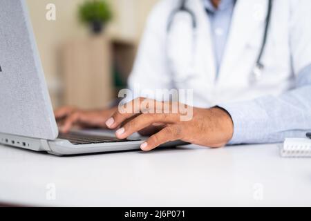 Close up shot of doctor hands using laptop at hospital - concept of technology, healthcare services and online consultant. Stock Photo