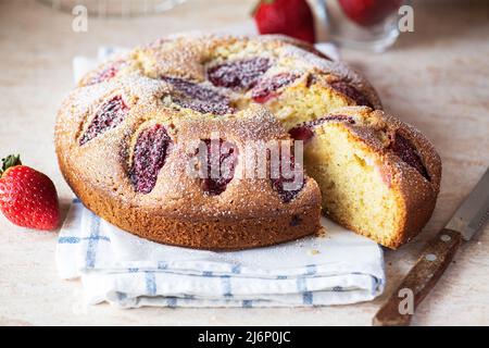 Sliced delicious strawberry one layer cake powdered with sugar. Close up. Stock Photo