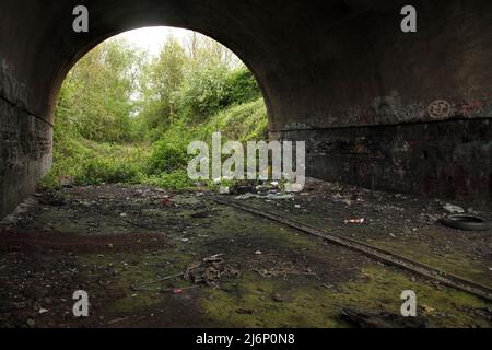 Brick arched bridge over the dismantled railway line from Scunthorpe, UK into the nearby steelworks under Rowland Road. Stock Photo