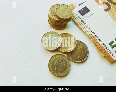 Concept of euro banknotes and coins at white background. European currency. Coins of 1 euro, 2 euro and cents. 50 euro banknotes Stock Photo