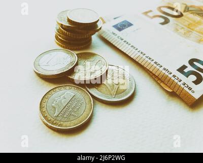 Concept of euro banknotes and coins at white background. European currency. Coins of 1 euro, 2 euro and cents. 50 euro banknotes Stock Photo