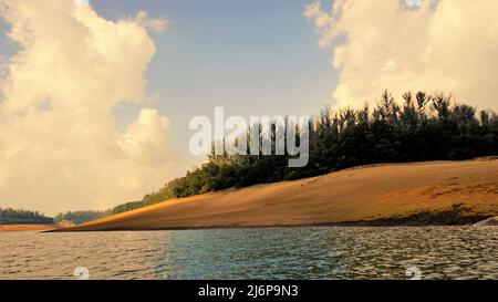 Beautiful view of Pykara Lake, Ooty, Tamilnadu during sunset. Awesome scenery of landscapes of sky,water,sunset and green bushes visible from boat rid Stock Photo