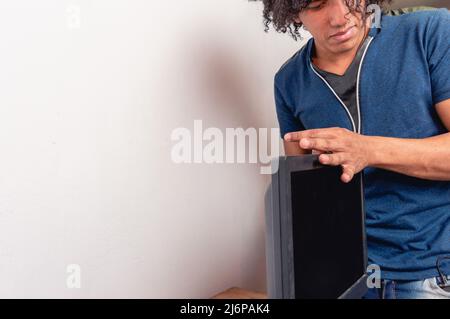 young afro brunette man in room installing computer monitor on wooden desk, technology concept, copy space. Stock Photo