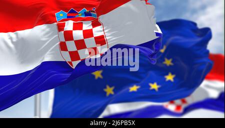 Detail of the national flag of Croatia waving in the wind with blurred european union flag in the background on a clear day. Democracy and politics. E Stock Photo
