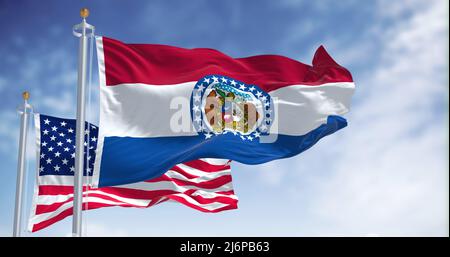 The Missouri state flag waving along with the national flag of the United States of America. In the background there is a clear sky. Missouri is a sta Stock Photo