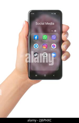 Kiev, Ukraine - January 20, 2022: Hand holds mobile phone with icons of popular social media mobile apps on its screen, such as: Facebook, Messenger, Stock Photo