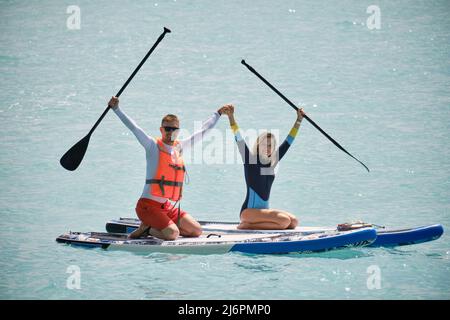 Man and woman paddling on sup board Stock Photo