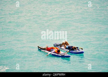Man and woman relaxing on sup boards Stock Photo