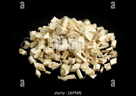 Pile of dry marshmallow roots isolated on black background. Althaea officinalis chopped Stock Photo