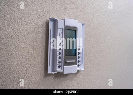 Close up view of a white air cooling and heating control panel on an off white colored wall inside a house Stock Photo