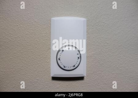 Close up view of a white air cooling and heating control panel on an off white colored wall inside a house Stock Photo