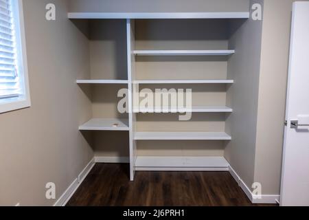 Straight on view of a white shelving system inside a closet in a bedroom Stock Photo