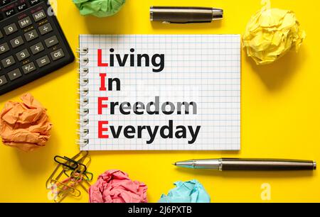 LIFE living in freedom everyday symbol. Concept words LIFE living in freedom everyday on beautiful yellow background. Black calculator. Business LIFE Stock Photo