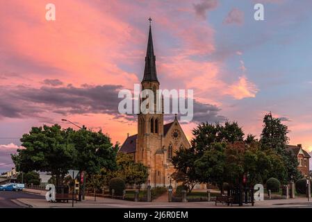 St Mary's Catholic Church in Mudgee, New South Wales with a vibrant and dramatic pink sky Stock Photo