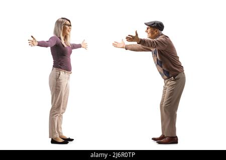 Full length profile shot of an elderly man and a young woman spreading arms to hug each other isolated on white background Stock Photo