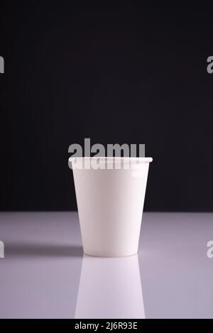 white paper cups on white table and dark background Stock Photo