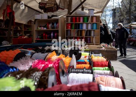 Selective focus, various type of ribbon and rope fabric rolls are sold on stall in street outdoor market. Stock Photo