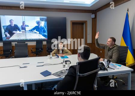 Ukrainian Head of the Presidential Administration Andriy Yermak, right, waves during a teleconference with American businessman, member of the Board of Tesla and SpaceX, Kimbal Musk, from the situation room, May 3, 2022 in Kyiv, Ukraine. Attending the meeting with Yermak was Deputy Prime Minister, Minister of Digital Transformation Mykhailo Fedorov. Stock Photo