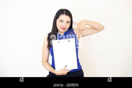 Cute and successful CEO assistant, wearing blue blouse, happily showing the results of her company, holding a clipboard with her right hand, on white Stock Photo