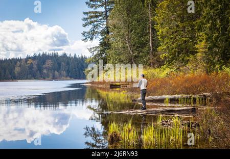 Beautiful landscape of a lake in a forest and fishing man. Rolley Lake Provincial Park near the town of Mission in British Columbia, Canada. Travel ph Stock Photo