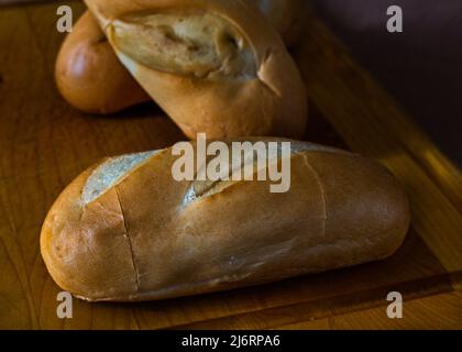 Fresh home-made milk rolls, tasty bread, rolls, everything on a cutting board and everything in a breakfast atmosphere. Stock Photo