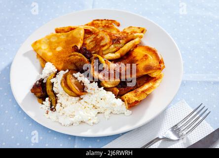 Sweet crepes with cottage cheese and baked apples with cinnamon Stock Photo