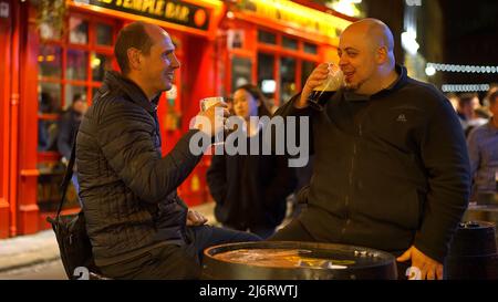 Guys drinking a beer in the Temple Bar district of Dublin by night - travel photography Stock Photo