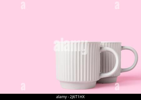 Two ceramic cups on pink background Stock Photo