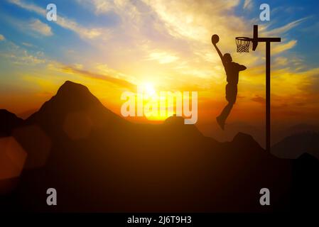 Driving and goals A man places a basketball goal on top of a mountain with sunset Stock Photo