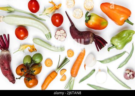 Food concept. Pattern made of autumn vegetables. Tomatoes, onion, cucumber, carrot, garlic, red beet, pepper, zucchini, maize and green haricot on whi Stock Photo