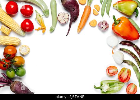 Healthy eating concept. Tomatoes, onion, carrot, garlic, red beet, pepper, maize and green haricot on white studio background wall. Creative layout ma Stock Photo