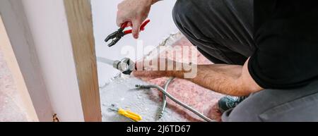Plumber doing heating installation on a construction site Stock Photo