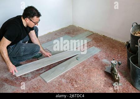 Bricklayer placing tiles to install a floor Stock Photo