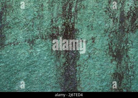 Crumbly textured green and black concrete wall with deep crevices and cracks in Bali, Indonesia Stock Photo