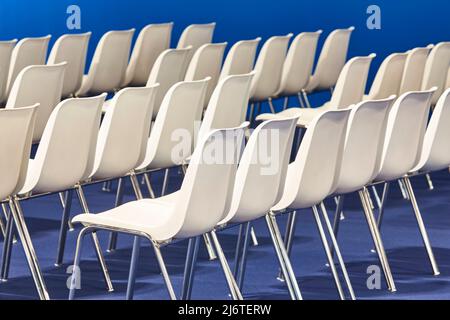 Contemporary white plastic chairs in a conference room. Workshop Stock Photo