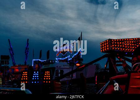 The blue and red lights of the Jetfire funfair ride brighten the night ...